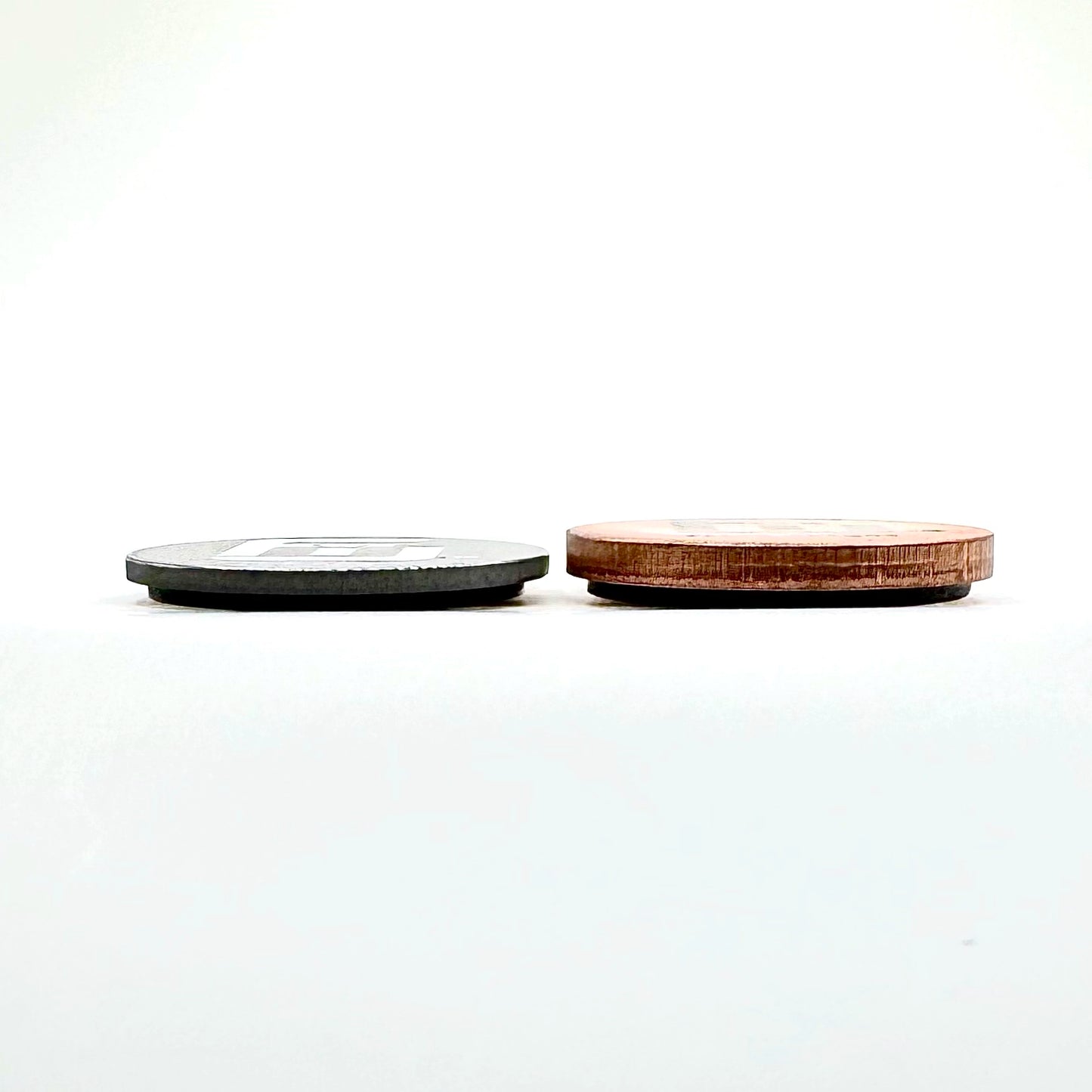 an 18g Copper flick weight next to a 18g Tungsten Flick weight to demonstrate the density and thickness difference between the different types of Flick weights.